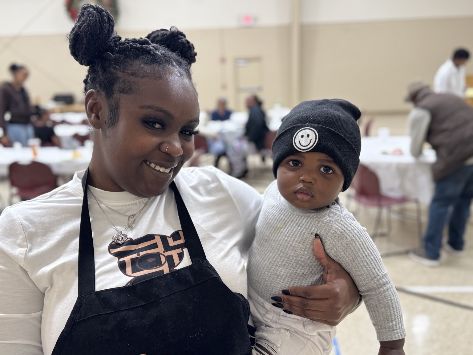 Volunteer holding a baby during Community Thanksgiving