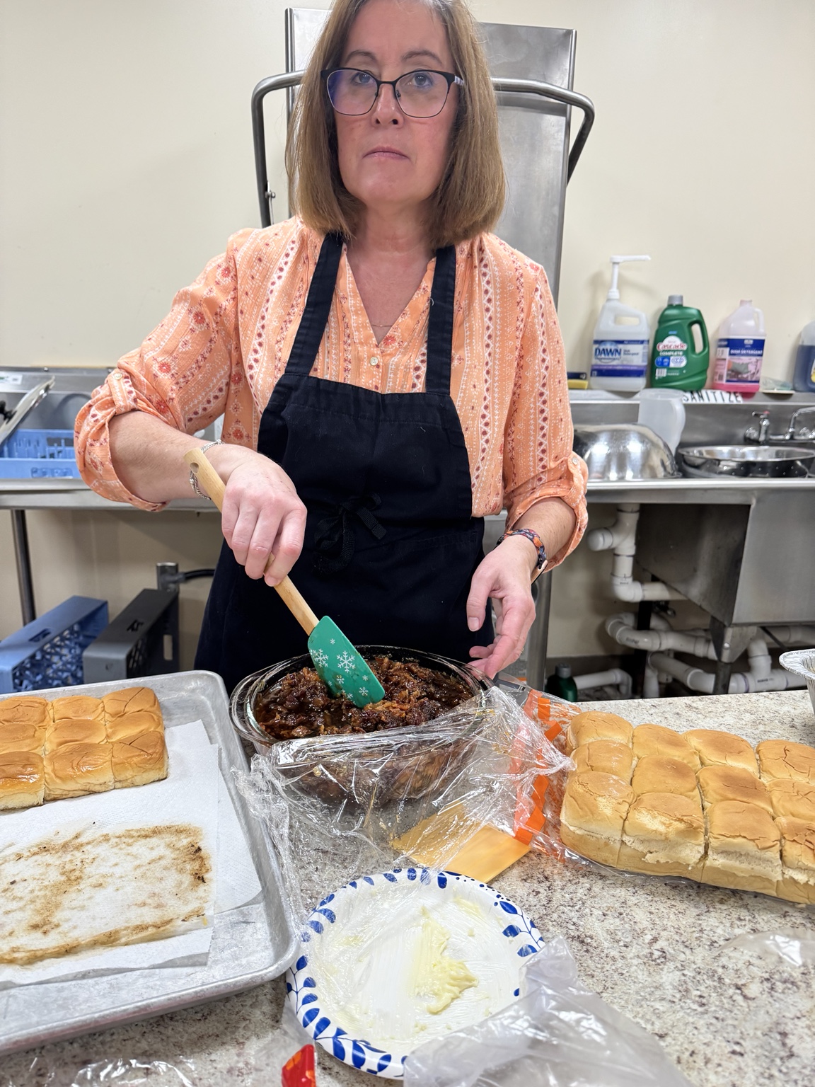 Volunteer preparing baked dishes for Thanksgiving dinner