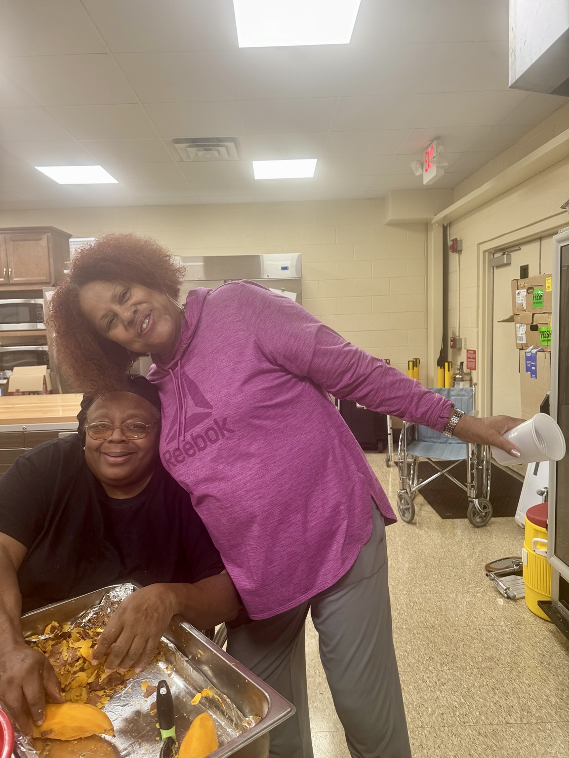 Kitchen volunteers smiling while preparing Thanksgiving food