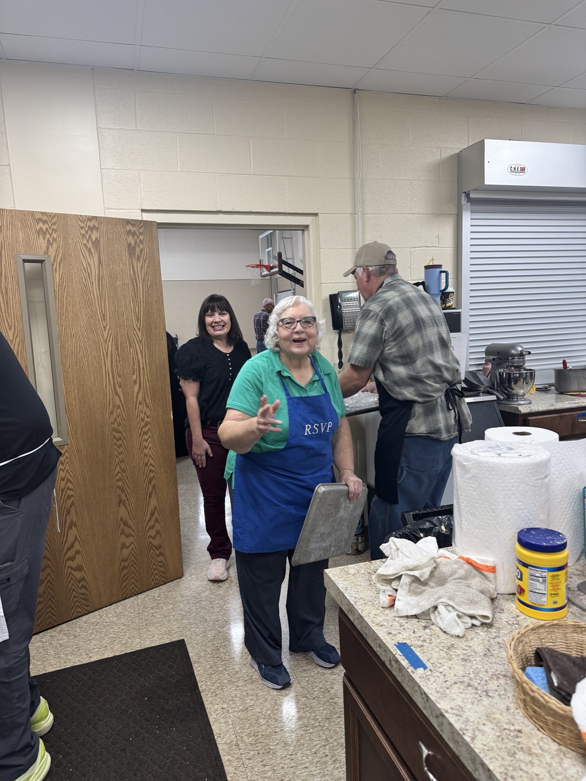Volunteers smiling together in the kitchen
