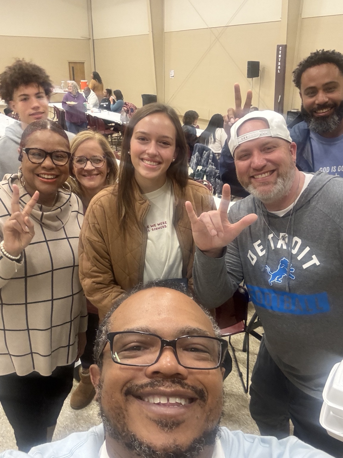 A diverse group of volunteers and guests smiling together